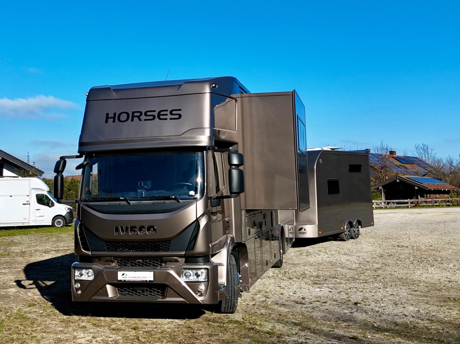 Frontale Ansicht eines braunen IVECO Pferdetransporters mit Pop-Out und Pferdeanhänger