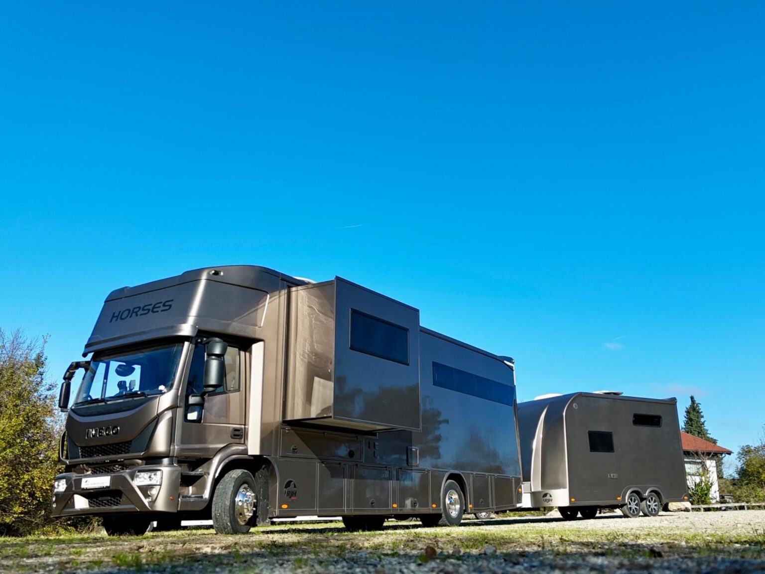 Niedrige Frontansicht eines IVECO Pferdetransporters mit Pferdeanhänger auf freiem Gelände