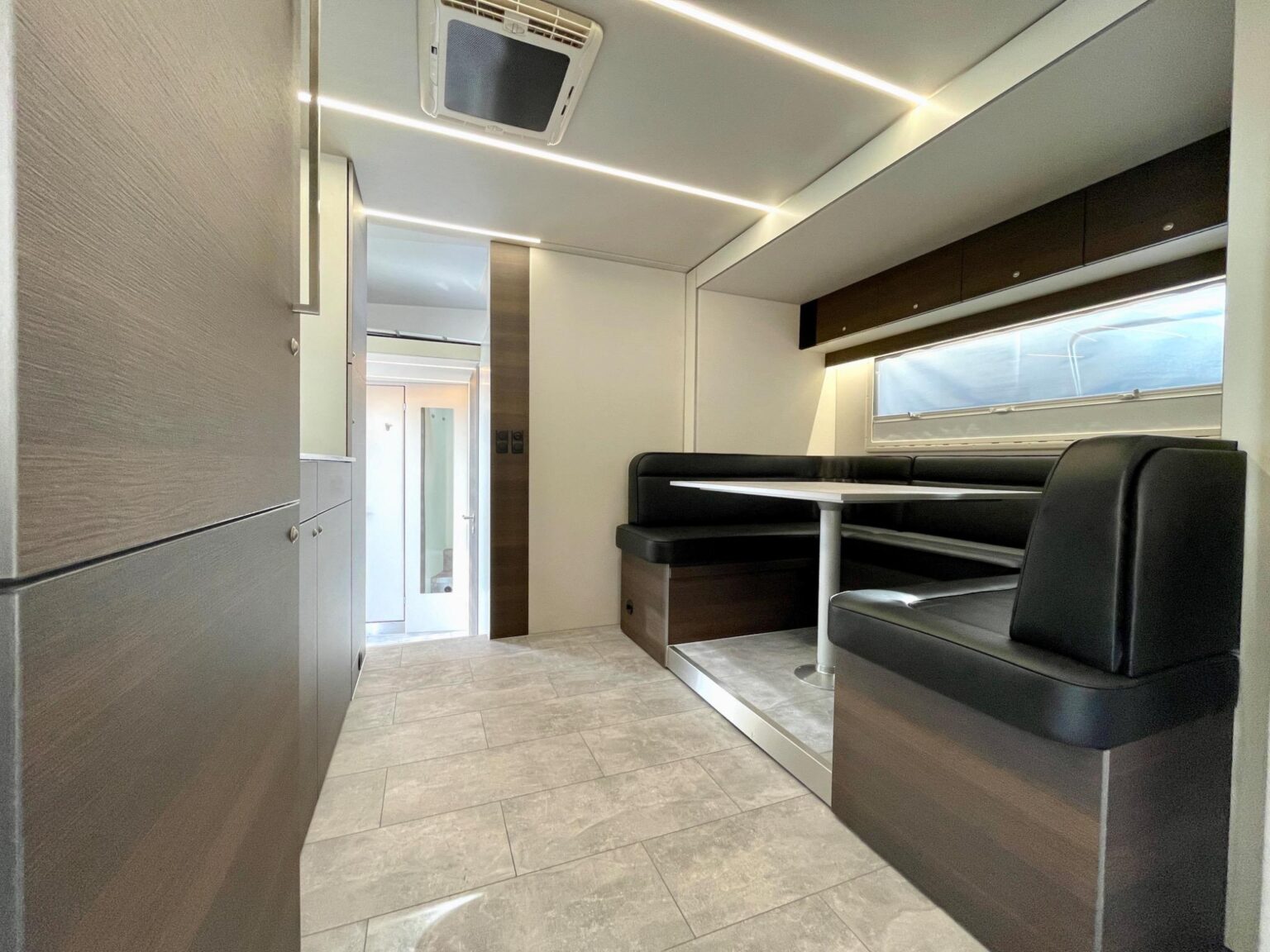 Wohnbereich im Pferdetransport mit gemütlicher Sitzecke und gefliestem Boden