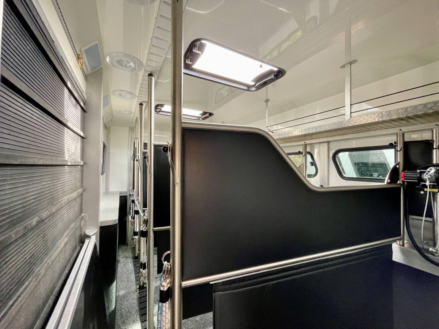 Pferdeabteil mit Trennwänden und Oberlichtern und Seilwinde im Innenraum des Transporters