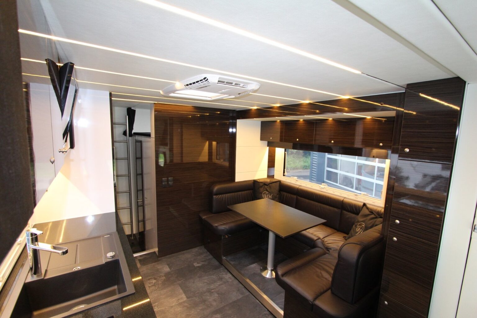 RJH Exclusive H5 Wohnbereich mit braunen Polstern und Beleuchtung